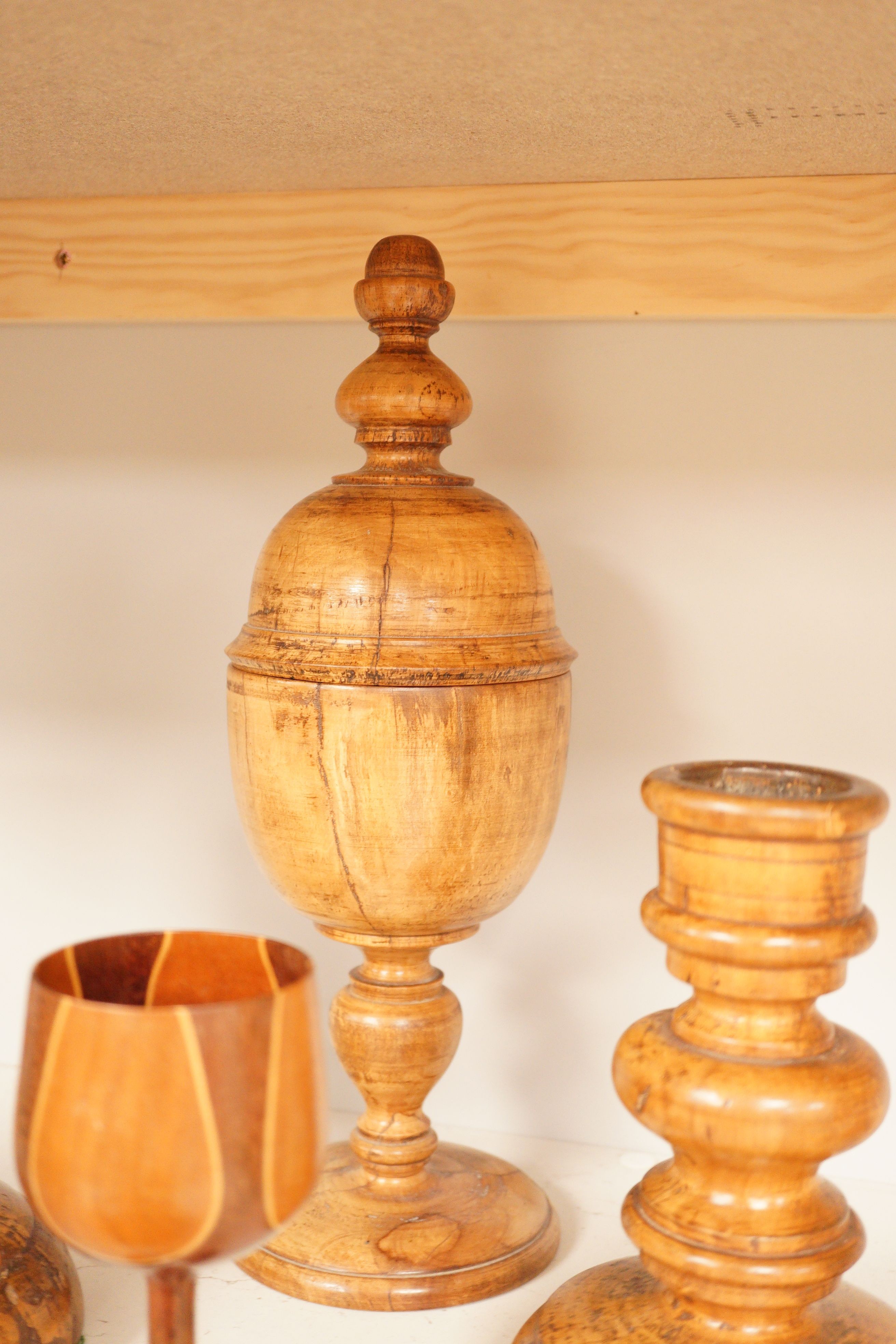 A treen goblet and cover, two candlesticks, a cup and a coaster